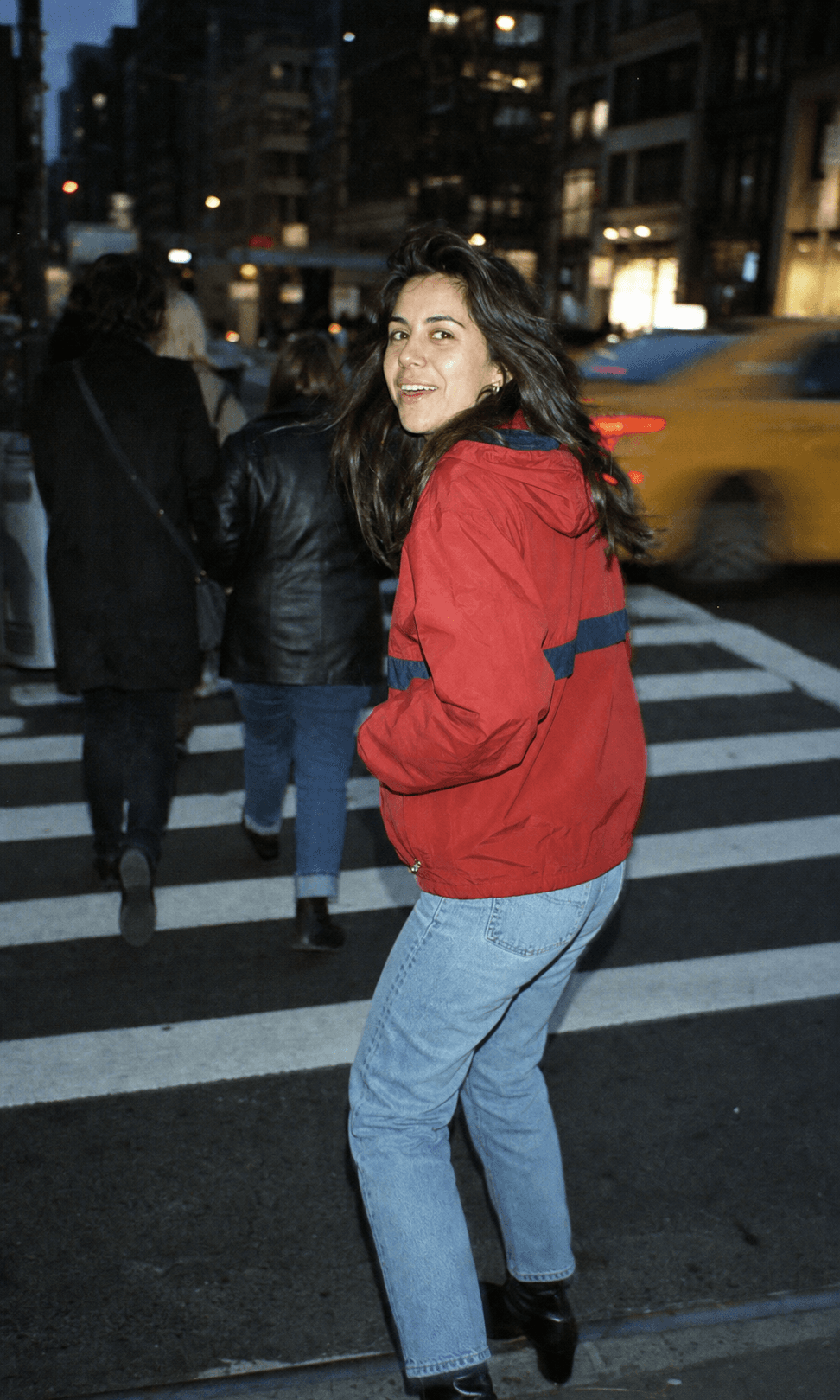 A woman turning toward the camera in a New York crosswalk